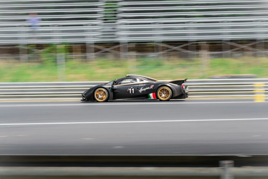 A black race car speeds down a track.