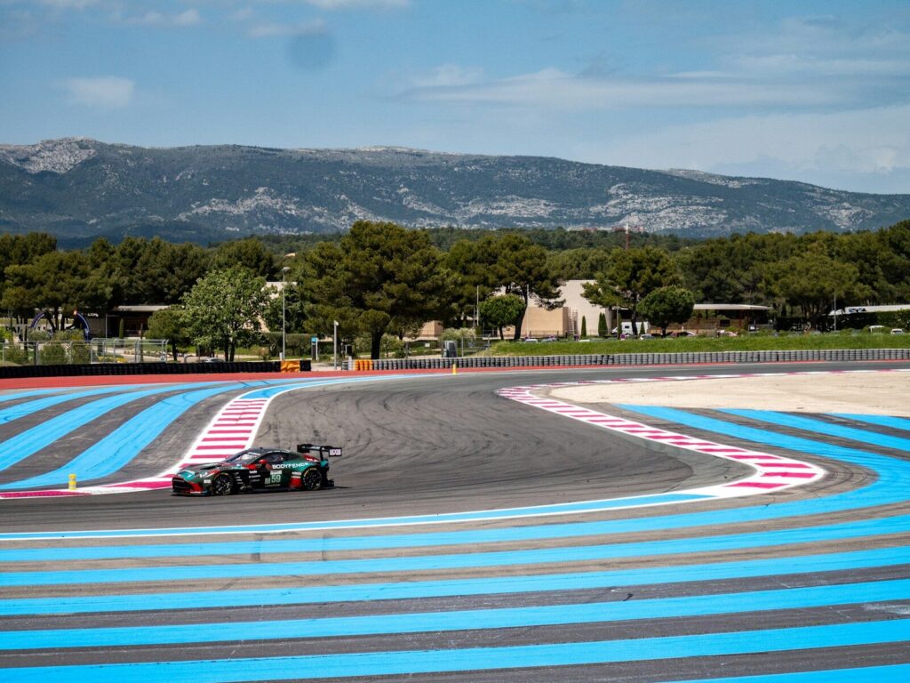 A race car speeds around a colorful track.