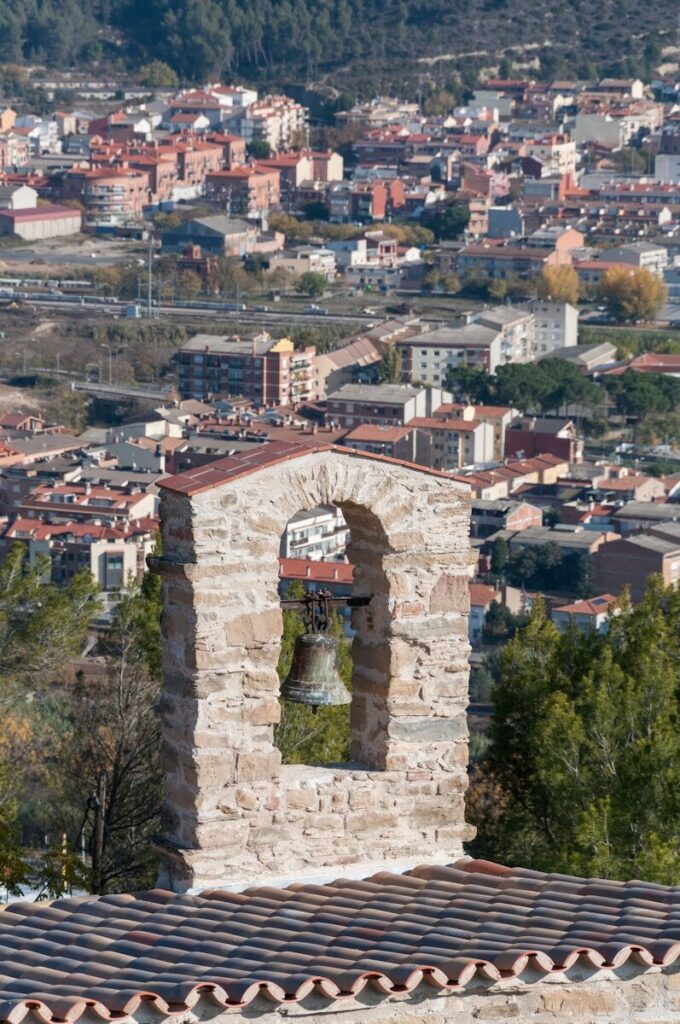 a bell tower with a view of a city in the background